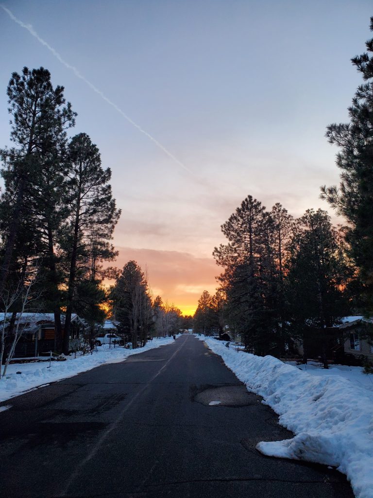 Winter sunset over a snow-lined street in Munds Park, Arizona